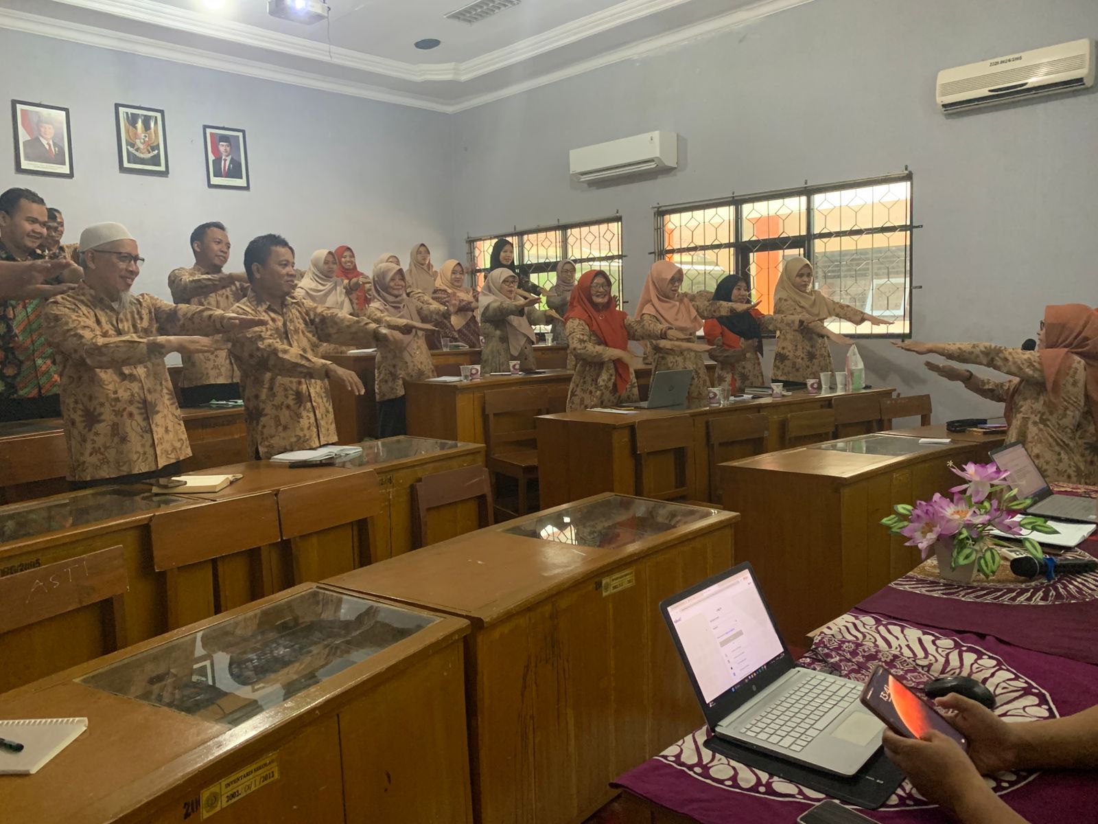 Guru sedang melakukan ice breaking dengan mengangkat tangan